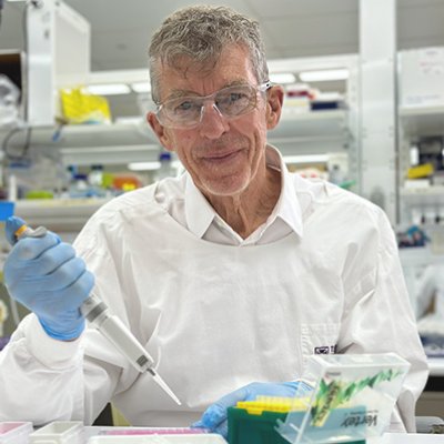 Emeritus Professor Ian Frazer uses a pipette in a lab at TRI